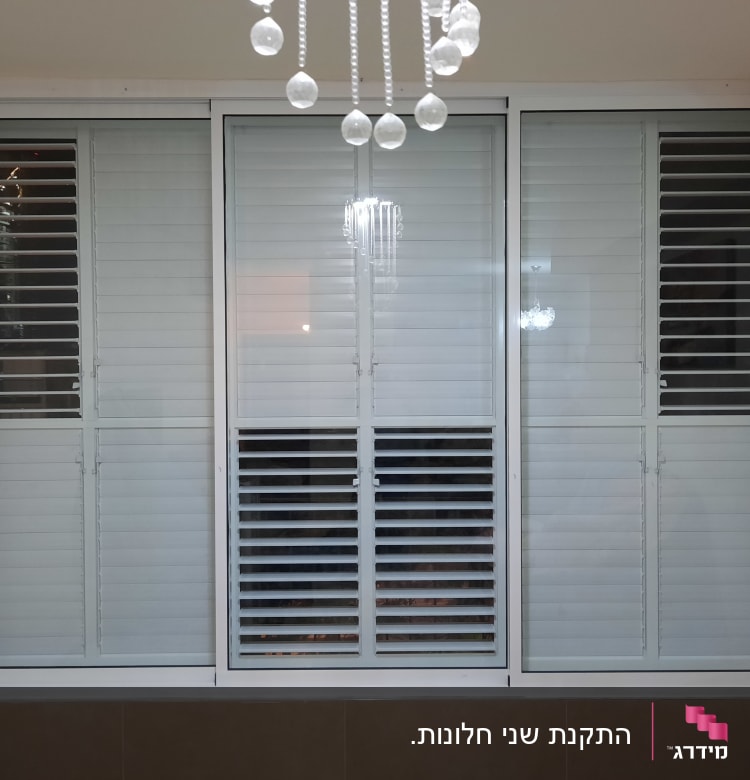 תריסי אלומיניום לבנים בחלון גדול